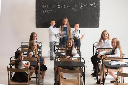 小学生在课堂上课小男孩和女孩坐在课桌前回到学校图片