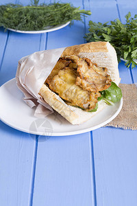 蓝木桌上美味的炸鱼三明治紧贴在图片