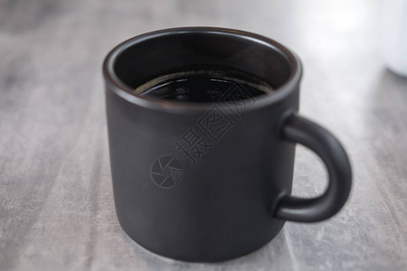 现代咖啡厅桌上一杯咖啡热咖啡杯黑陶图片