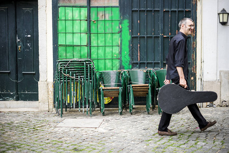 在葡萄牙里斯本街上音乐家带着他深图片