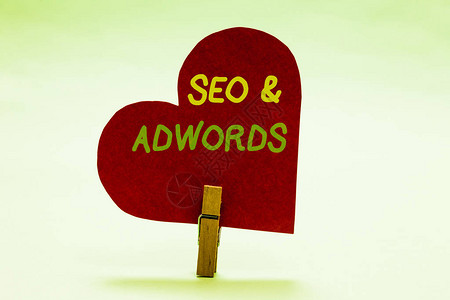 鼠标点击SeoandAdwords商业照片展示每点击数字市场营销GoogleAdsenseClothespin握着红纸心脏的背景
