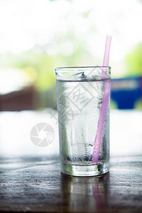 透明杯子用冷水倒在木制桌上的背景图片