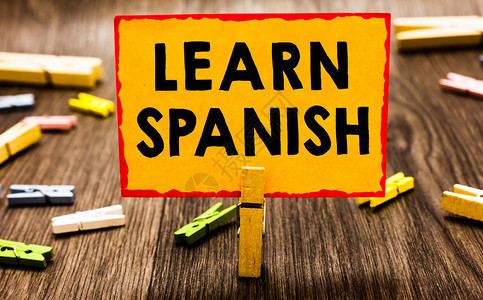 概念手写显示学习西班牙语商业照片展示西班牙翻译语言词汇方言语音衣夹拿着橙色纸图片