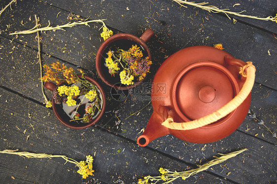 深色木质背景凉茶干草药和鲜花图片