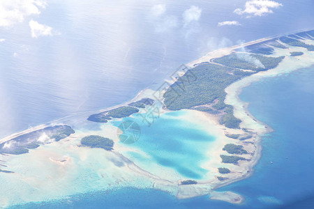 从飞机云层和海洋中可以看到珊瑚礁的景图片
