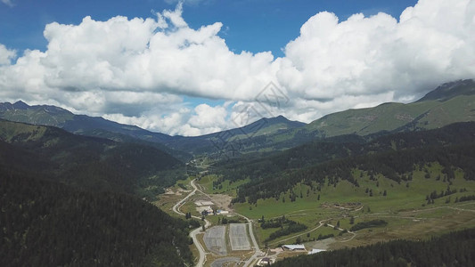 多云的天空覆盖的青山绿色高山的顶视图图片