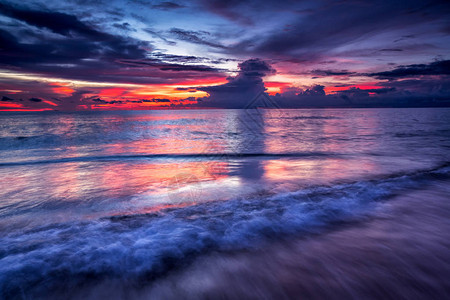 日落时沙滩上微软的蓝海浪以暮色的图片