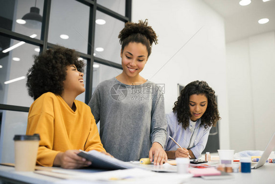 微笑的非洲裔美国女商人的创意团队在创意办公室计划新的启动项目头脑风暴合作才华横溢的大学生在工作室时装设计年轻积极的时髦图片