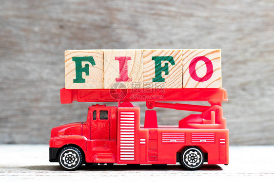 玩具消防梯式卡车在木材背景上用FIFO字封住字母块缩图片