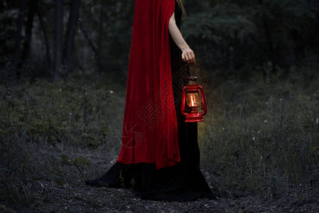 在黑暗森林中行走的有煤油灯的神秘女图片