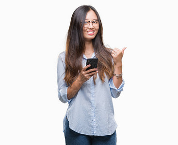 年轻的亚洲女在孤立的背景下用智能手机发短信图片
