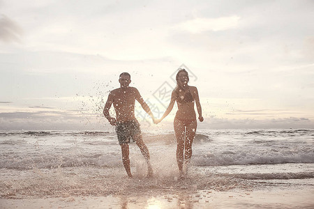 在沙滩日落的景色新婚夫妇在海上度图片