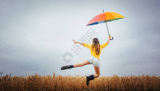 女人在雨中带着多彩的雨伞图片