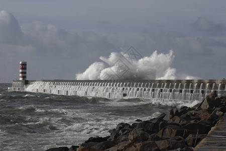 大暴风雨的海浪飞溅杜罗河mout北码头和灯塔图片