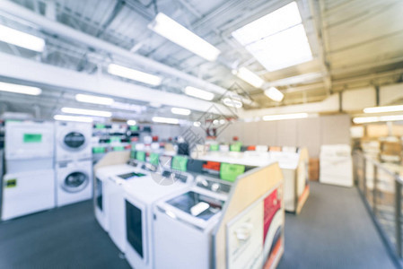 模糊的背景零售店与家电设备行展出的散焦洗衣机电动和燃气烘干机堆叠式洗衣中心冰箱背景图片