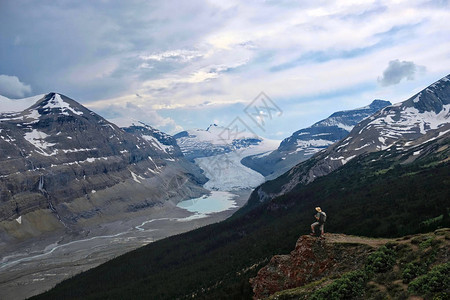 在加拿大落基山脉度假旅行山顶上勇敢的徒步旅行者在暴风雨的天空下看着哥伦比亚冰原川和冰碛湖的景色哥伦比亚冰原班夫贾斯珀公园加拿大落图片