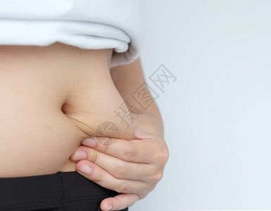 女人的手侧部抓着脂肪身体肚子肠糖图片