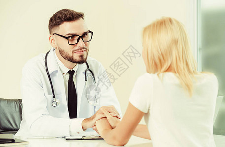 男医生在医院办公室帮助一名女病人图片
