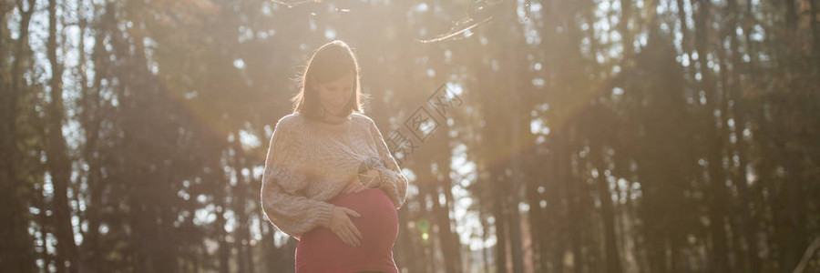 年轻孕妇在最后三个月亲切地抚摸她的肚子图片