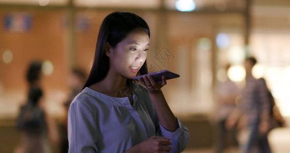 香港太平山妇女夜间使用移动电话发送音频背景