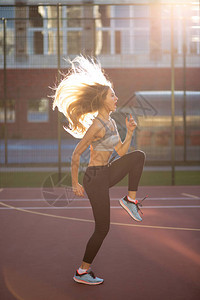 穿着运动服在网球场上跳长发的长发运动服图片