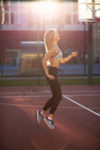 运动服装的快乐健身模式在柔软的夜晚阳光下的图片