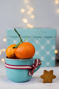 两杯新鲜的橘子在蓝色陶瓷杯中彩带在盒图片