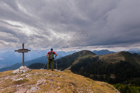 背着包站在山顶上的徒步旅行者背景图片