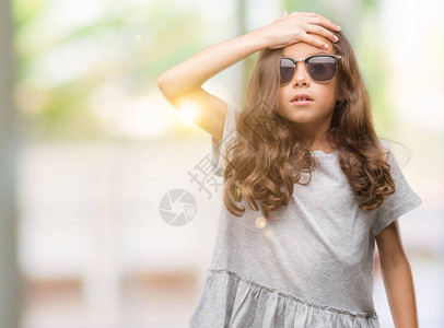 戴着墨镜的黑发西班牙裔女孩因错误而惊讶地用手捂着头图片