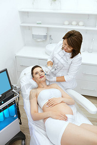 皮肤护理在美容诊所露脸的孕妇利用水力真空清洁剂进行美容感应的美容学专图片