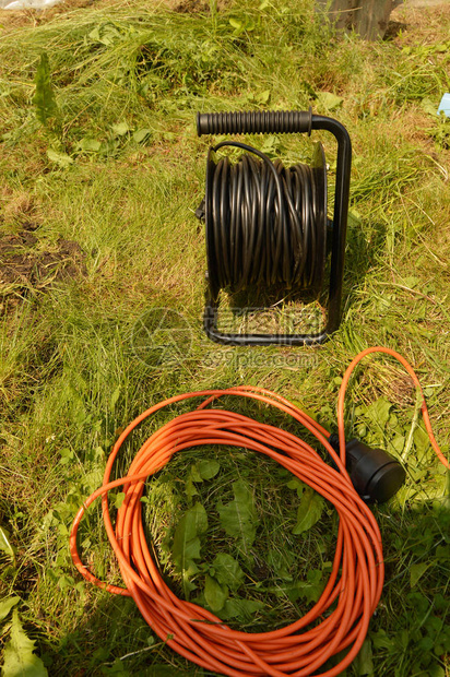在草地上装有电缆和电线的煤油图片