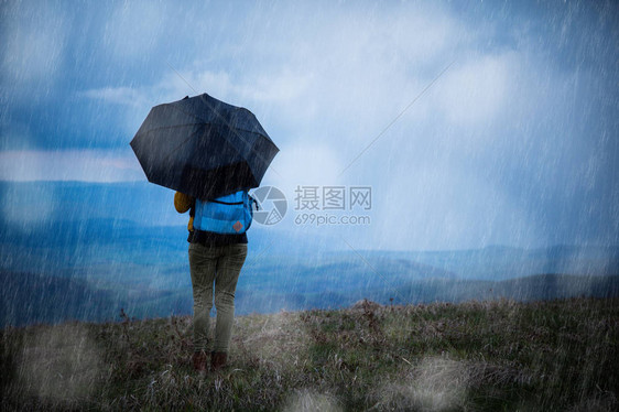 一个女孩在雨中撑伞的剪影图片