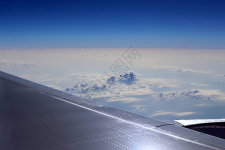 飞机翼下的多云天空背景图片