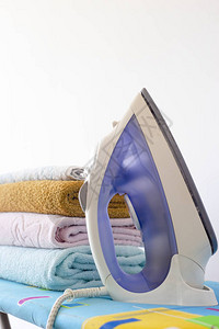 家用熨衣板上的毛巾烫衣服在一堆干净新鲜图片