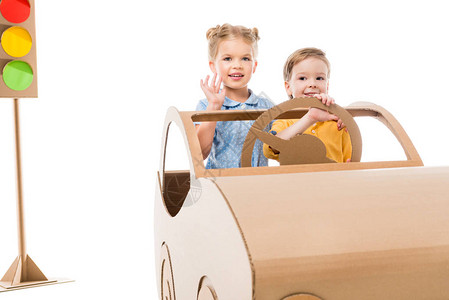 儿童驾驶纸板车背面有交通灯在白色图片