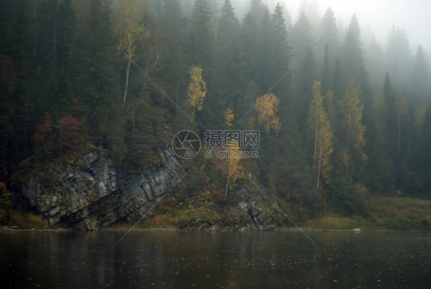 阴暗的模糊的秋天风景有雾水河带岩图片