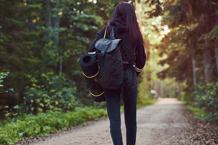 穿着连帽衫和牛仔裤的旅游女孩背影中图片