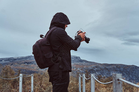 自然摄影师在挪威山上用照相机拍摄照片的旅游者们图片