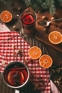 玻璃杯中自制热味果子酒和配有香料和新鲜橙子的图片