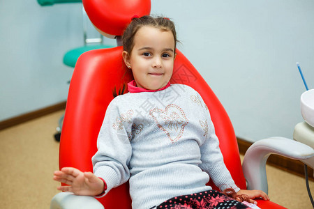 女婴微笑着在牙科椅上露出洁白的牙齿图片