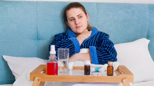患有流感和发烧的生病妇女躺在床上图片
