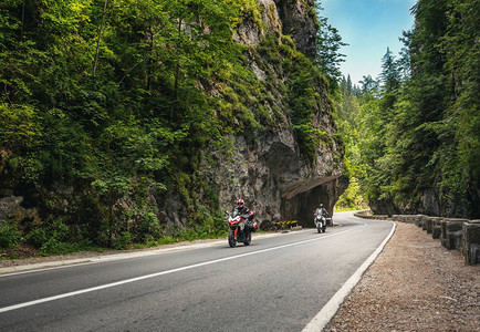 山路在罗马尼亚喀尔巴阡山脉的岩石之间穿行骑自行车的人在山路上图片