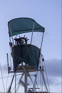 船长的桥上有个舵头帆顶着包起天线和一艘渔船图片