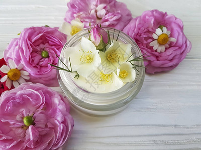 奶油化妆品玫瑰白色木质背景上的茉莉花图片