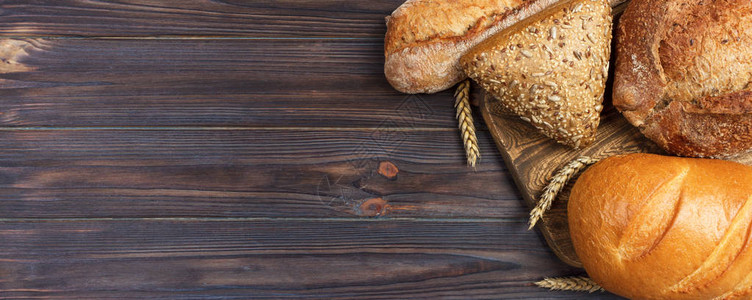 自制的小麦面包烤在木制背景上图片