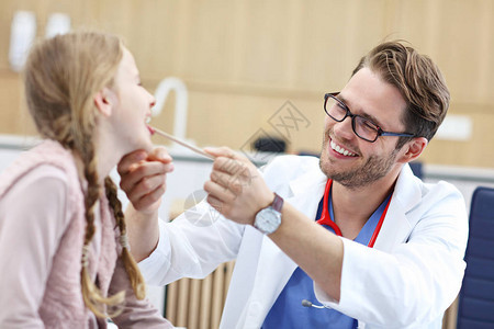显示在诊所的小女孩正在接受喉科医图片
