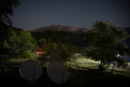 美丽的夜景与星夜山和森林有绿色草甸和山的夜森林在明亮的星夜图片