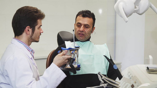 成年男子在诊所专业牙医处就医背景图片