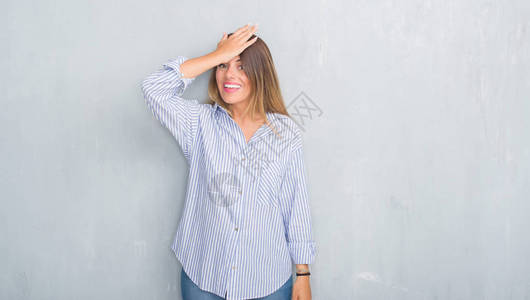 年轻的成年女在灰色的垃圾墙上穿着时尚的商务装背景图片