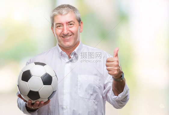英俊的老人在与世隔绝的背景下拿着足球图片